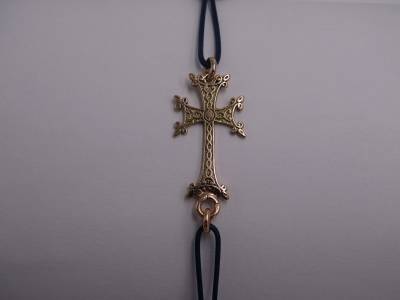 Croix Arménienne, en or 18 carats.0.98 gramme, montée sur cordon Noir tressé.